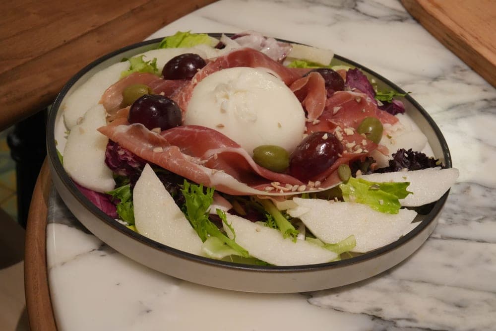Une salade de burrata, charcuterie et olives